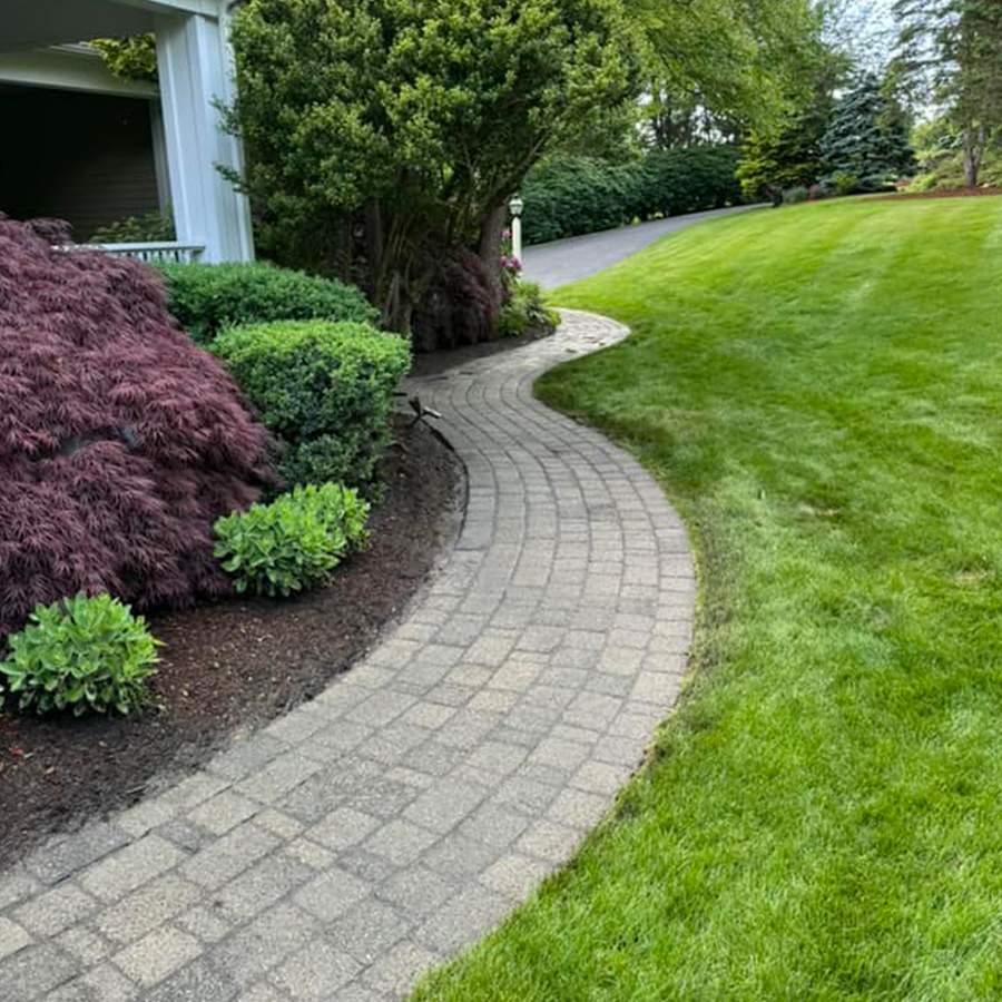 a brick walkway next to a house