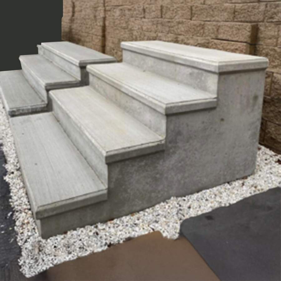 a concrete stairs next to a brick wall